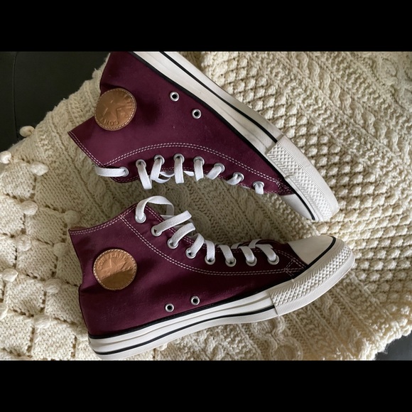 These are burgundy unisex Converse sneakers